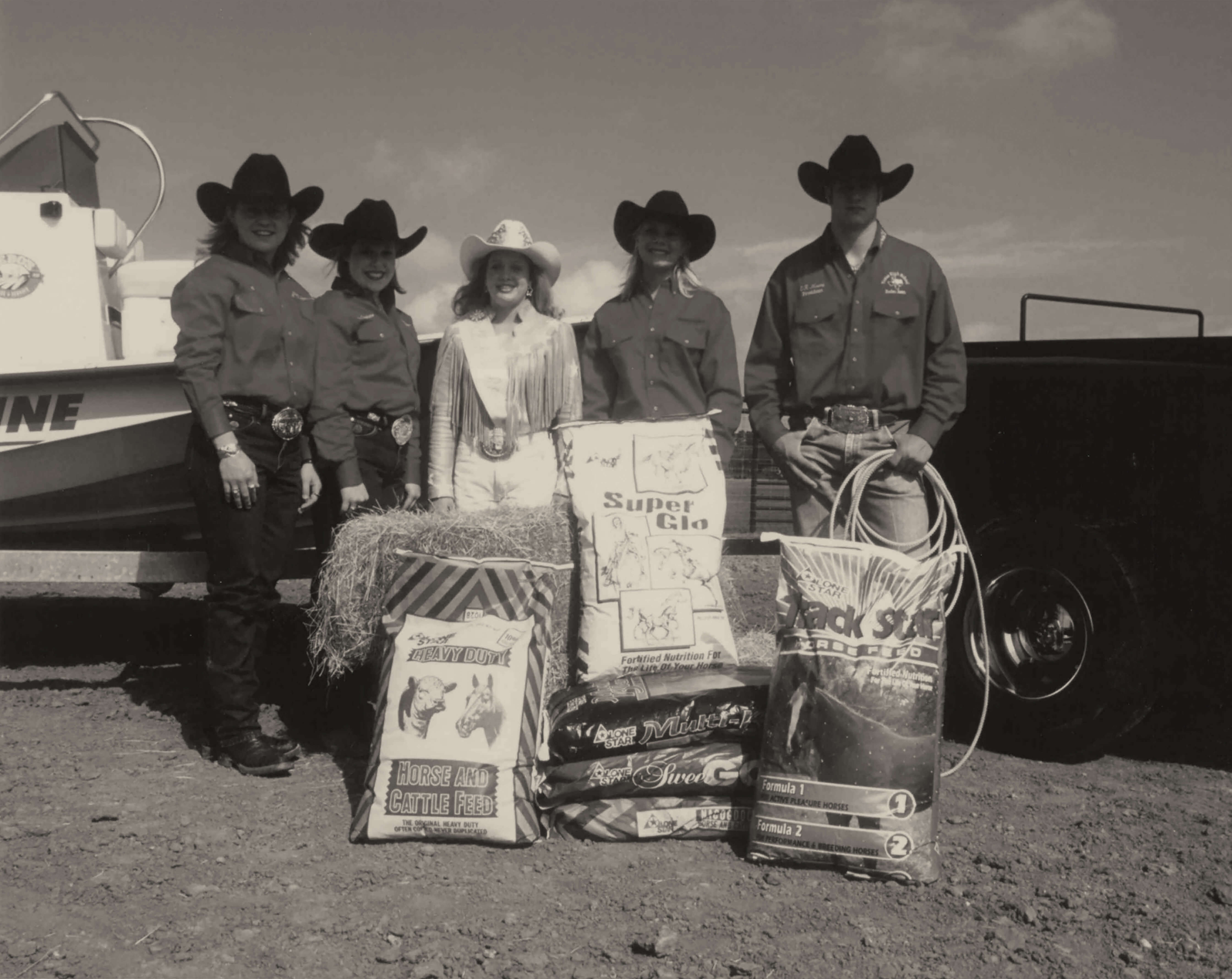 black and white photo of customers posing with lone star feed bags