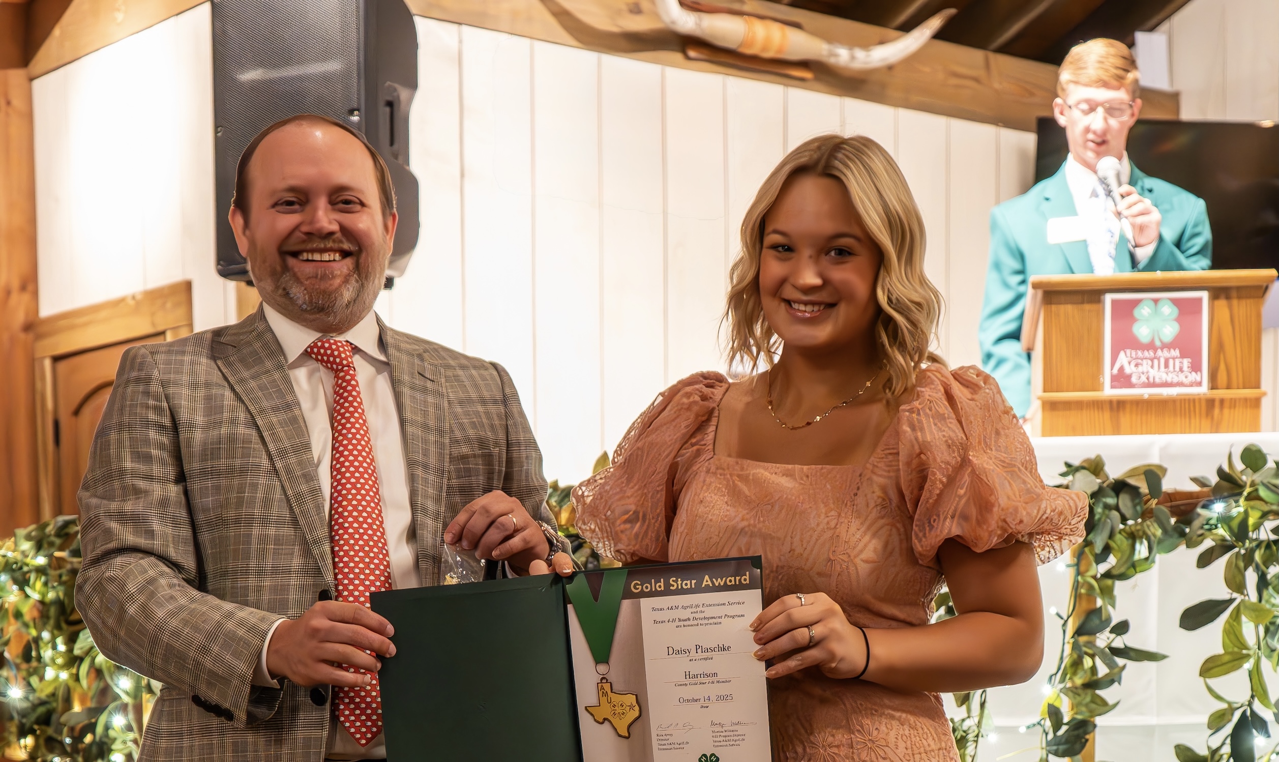 Man presenting award to young lady