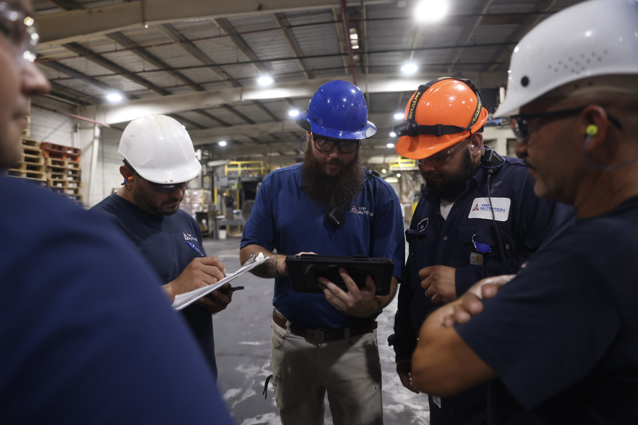 Group of men looking at an iPad and taking notes