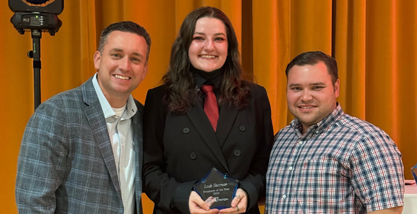 woman with award between two men