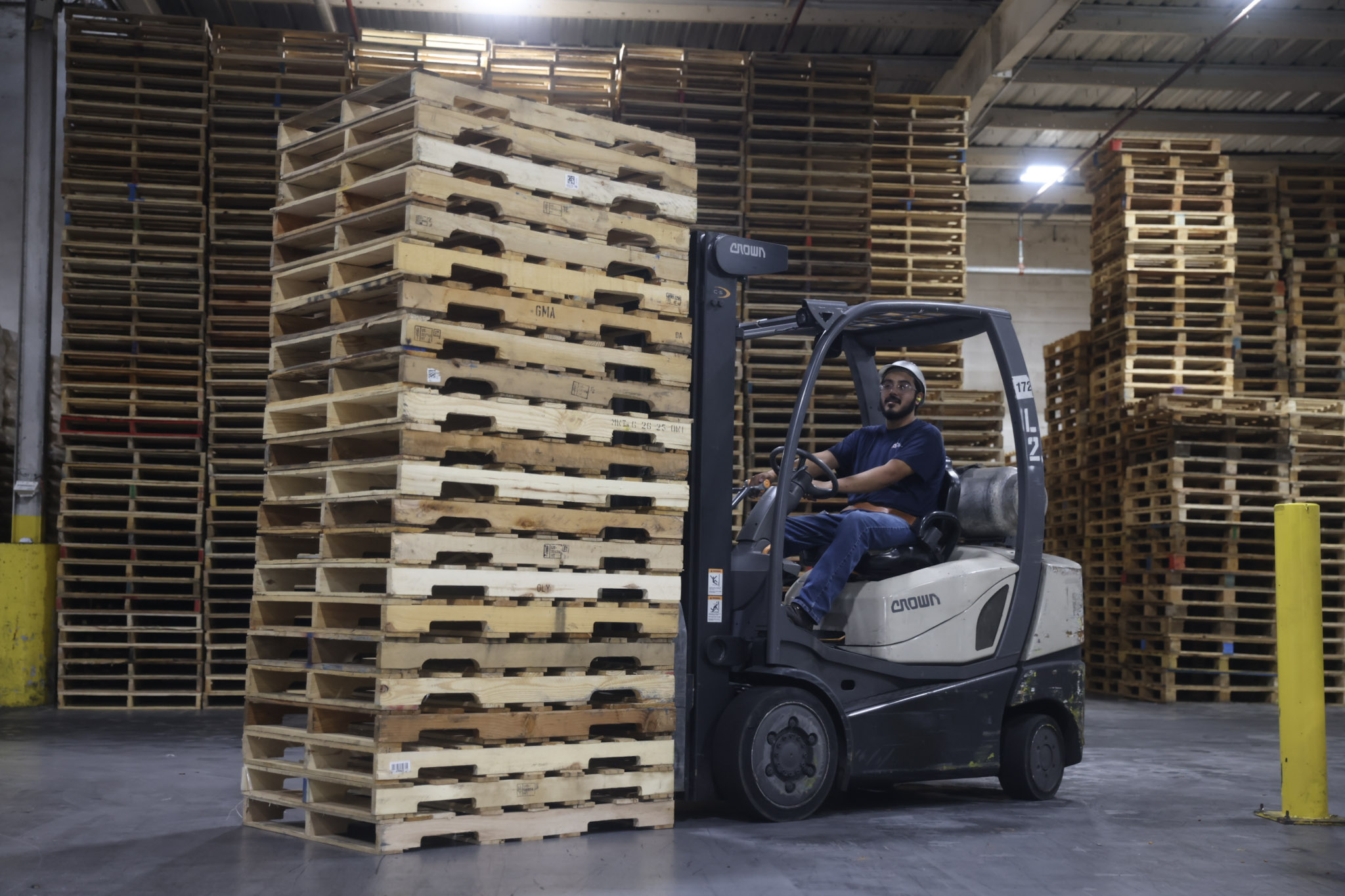 man on forklift with stack of pallets