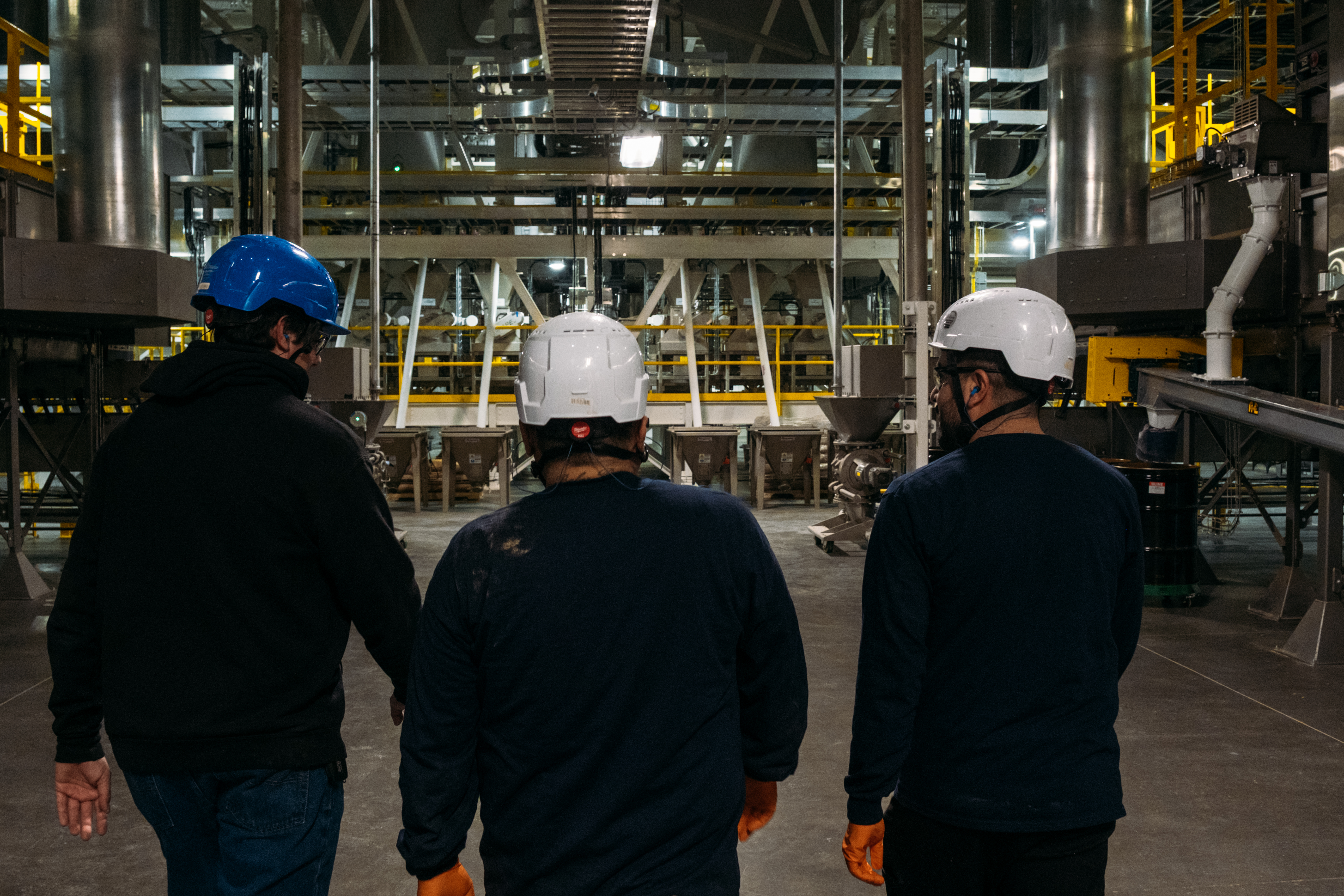 Three men walking into a facility