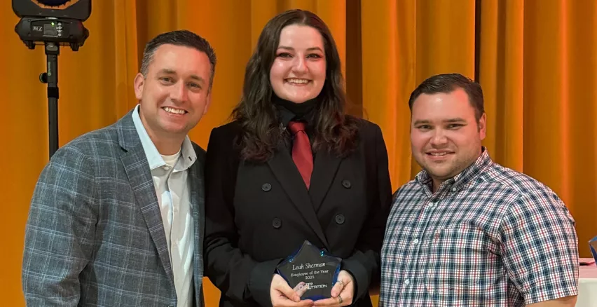 woman with award between two men
